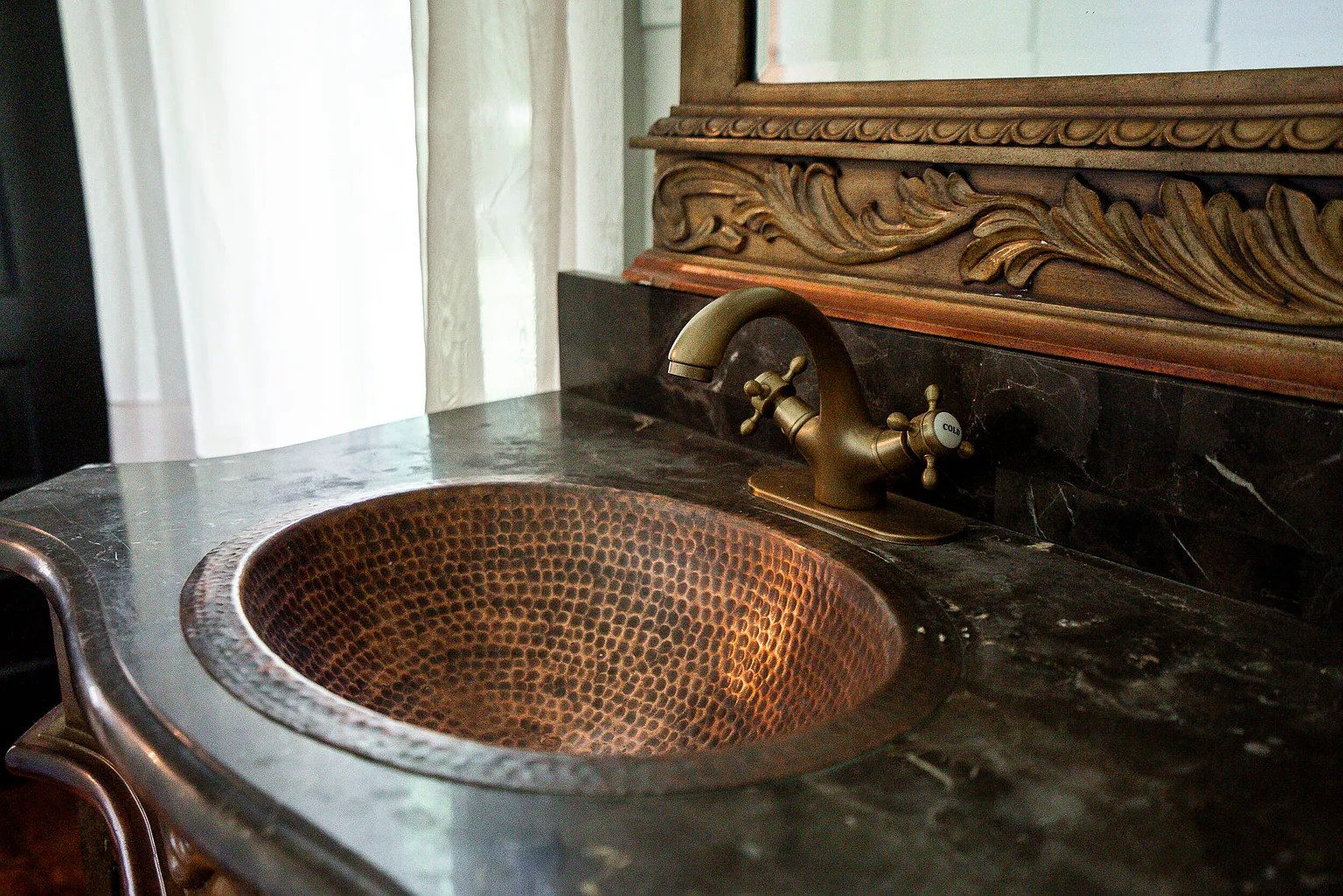 Rustic copper bathroom sink with warm patina and vintage charm