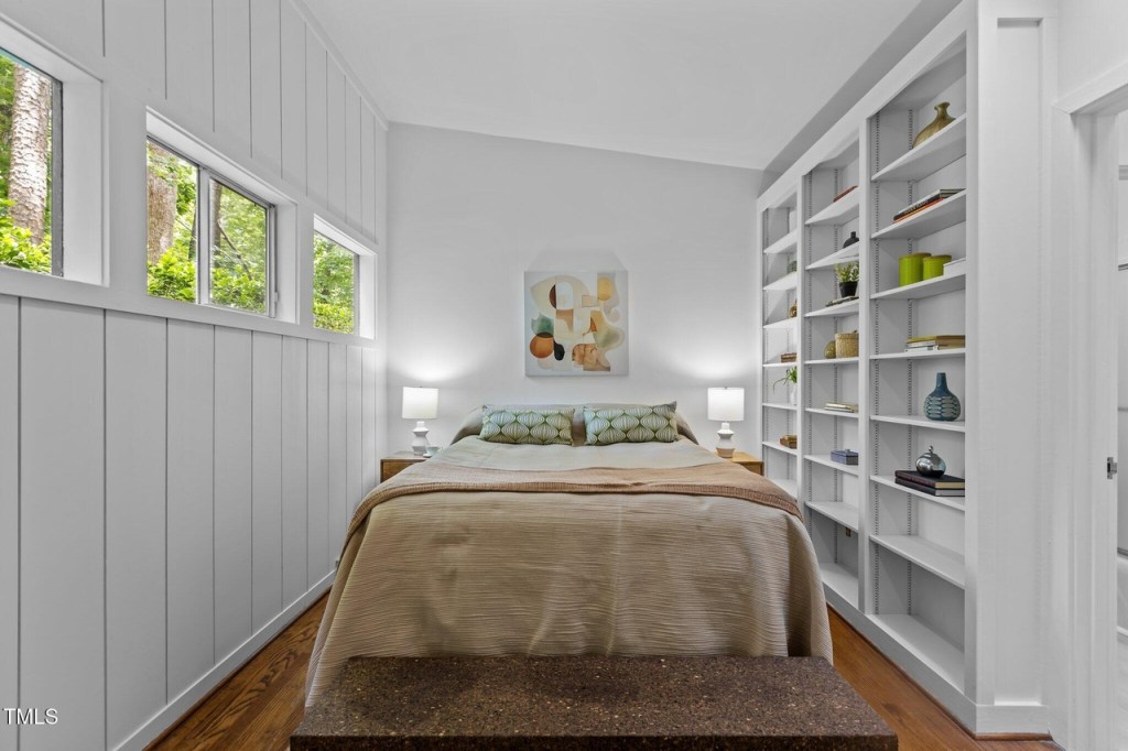 Bright bedroom in North Carolina mid-century modern house with built in bookshelves and clerestory windows.
