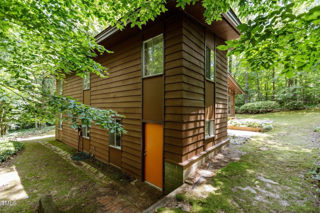 Private backyard of Durham mid-century home with natural landscaping

