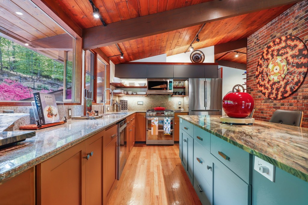 Mid-century kitchen with blue and brown cabinetry and natural wood tones with clerestory windows.

