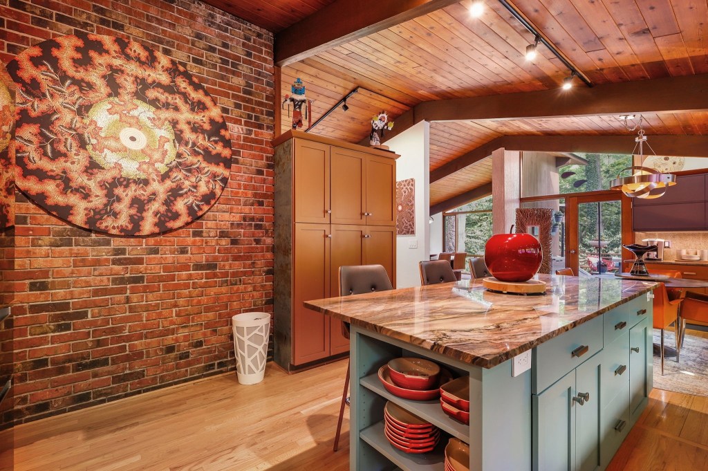 Mid-century retro kitchen with open cabinets and a brick wall and vaulted ceilings
