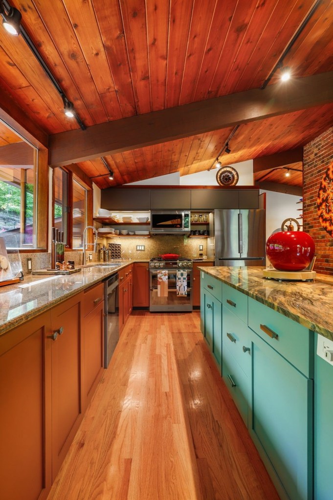 Mid-century kitchen with blue and brown cabinetry and natural wood tones with clerestory windows.
