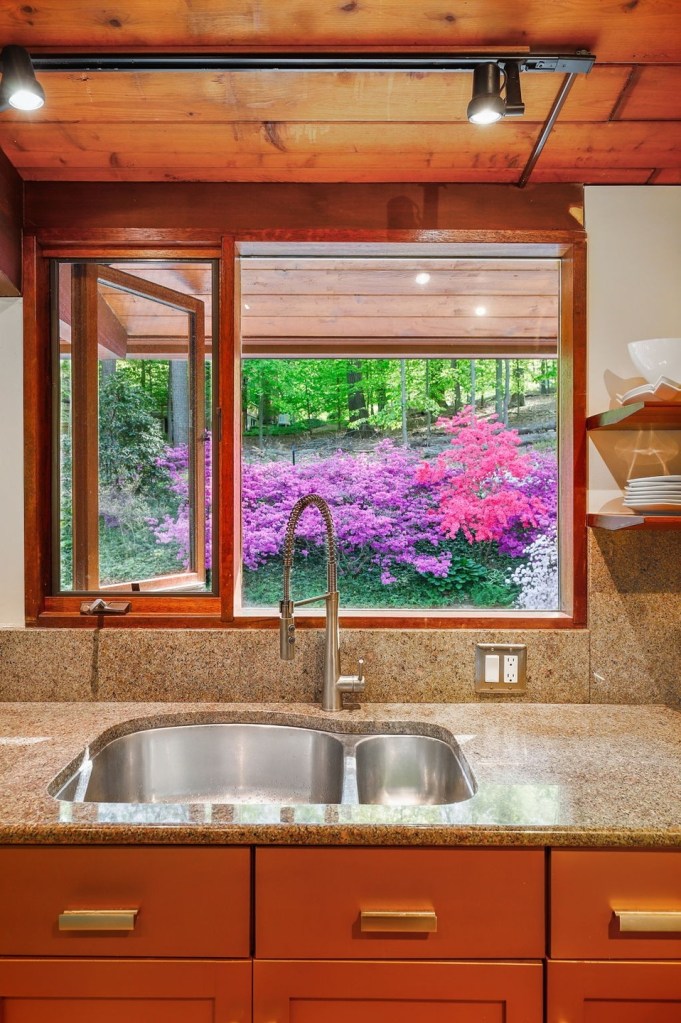 Mid century modern acorn deck house in towson maryland with large window above the kitchen sink