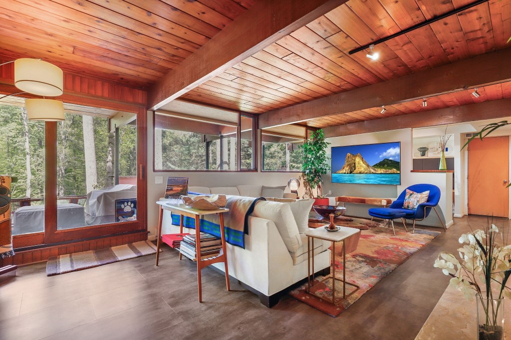 Cozy reading nook beside the wood-burning fireplace and glass walls

