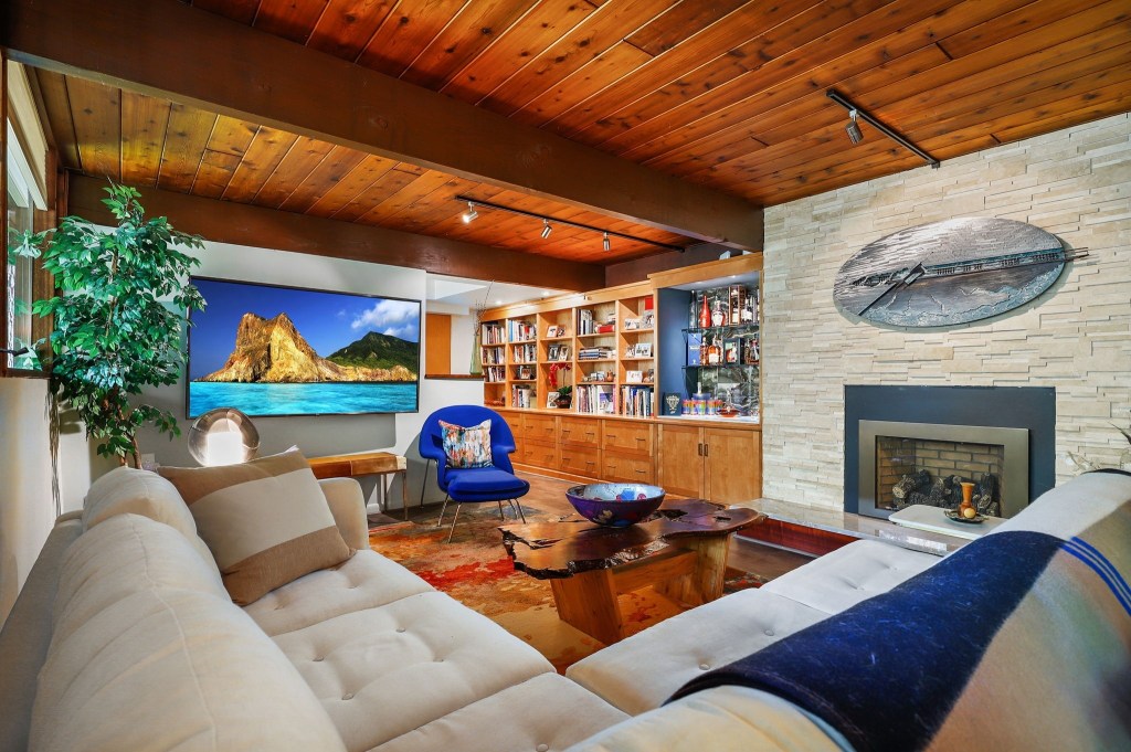 Cozy reading nook beside the wood-burning fireplace and glass walls

