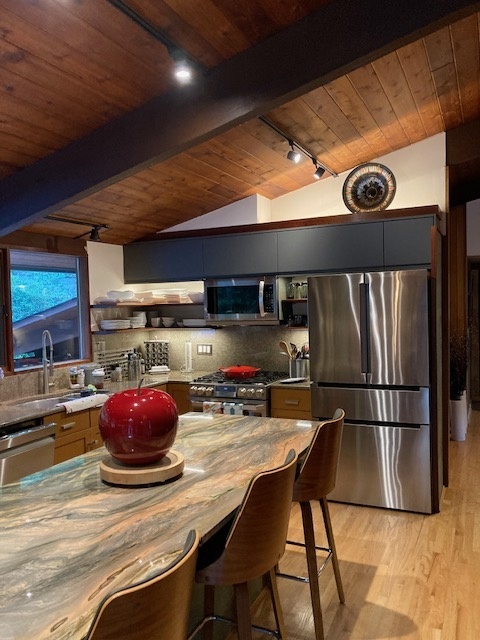 Retro kitchen with clerestory windows and warm wood cabinetry and floors.

