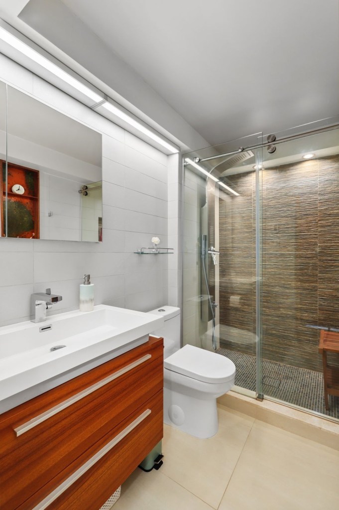 Retro bathroom with tiled walls and warm modern wood cabinetry

