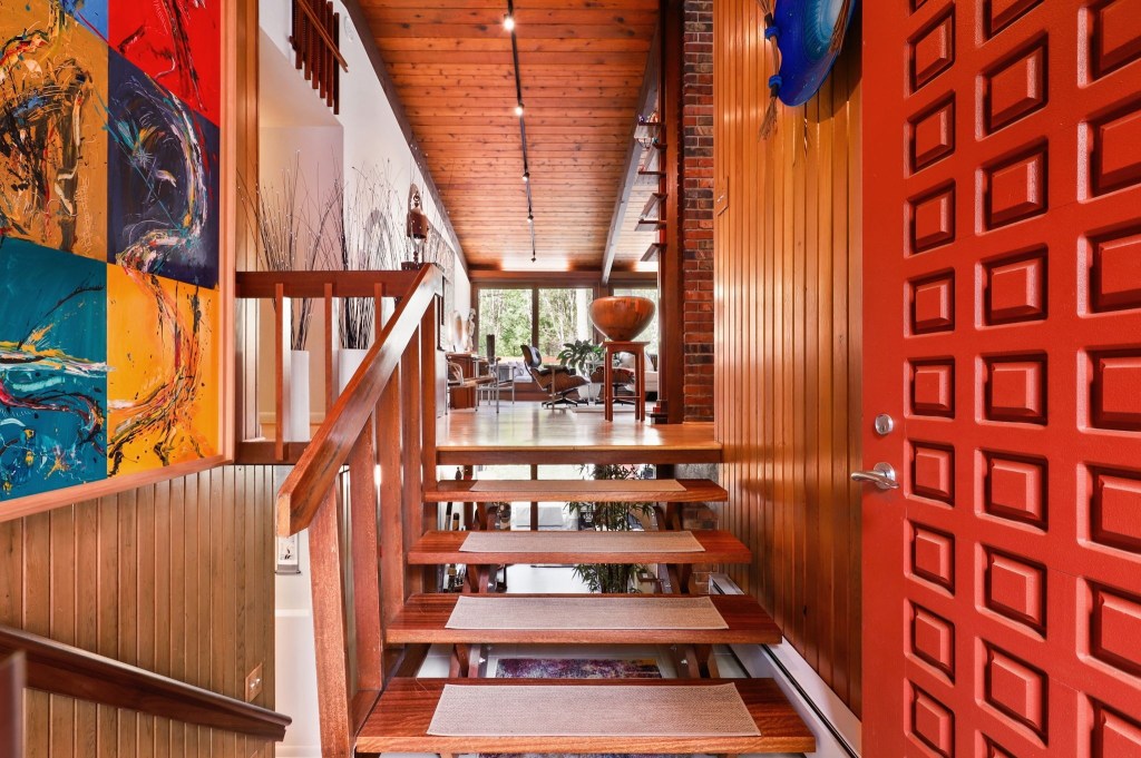 Mid century modern entry way with vintage decor and half of a floating staircase