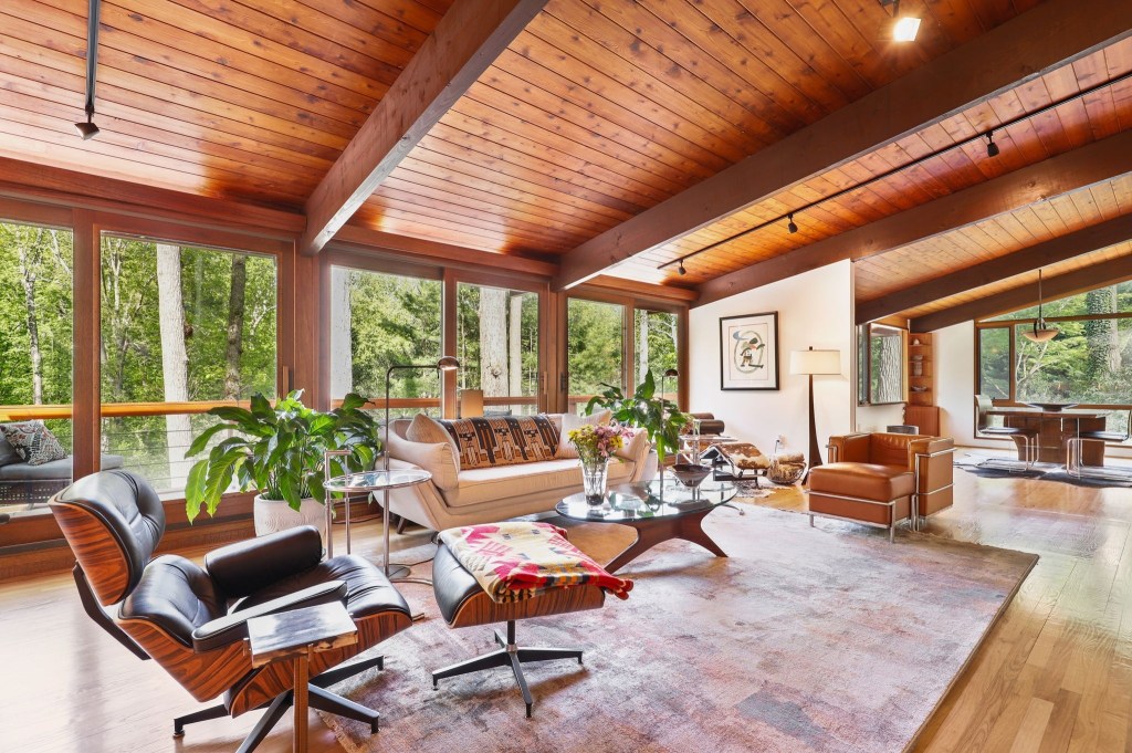 Open concept living space in a mid century modern house with exposed beams and vaulted ceilings. 