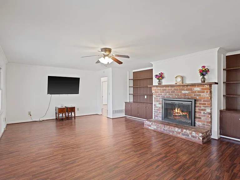 Bright and spacious living room with hardwood floors and natural light in Travelers Rest home with a fireplace

