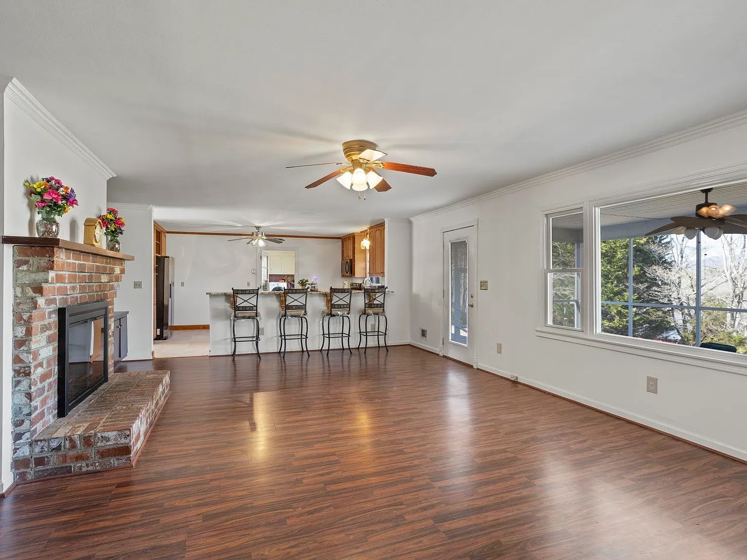 Charming country-style kitchen opens up to a living room with a picture window