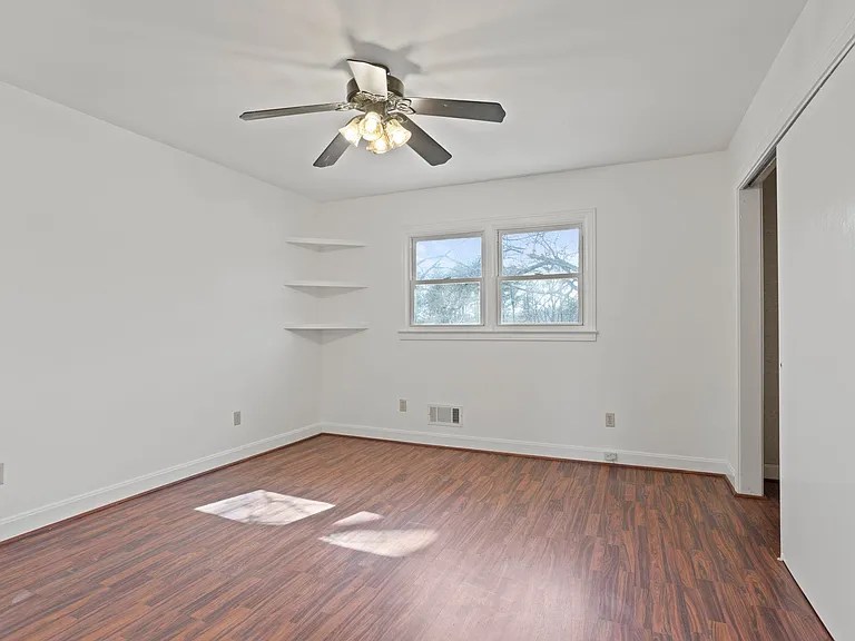 Flexible guest bedroom or home office space with natural light and neutral finishes

