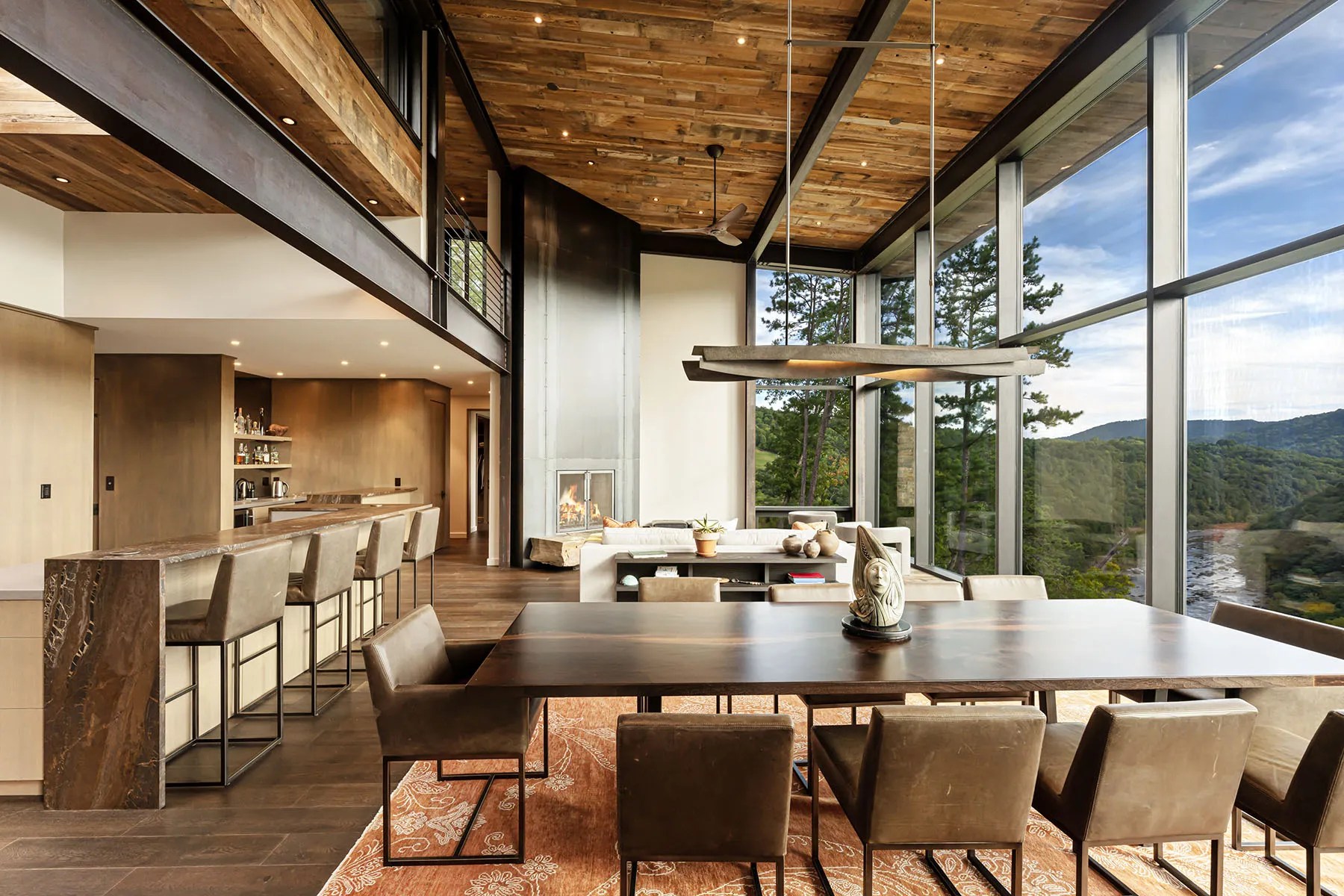 Open-concept living room with natural finishes and floor-to-ceiling windows overlooking nature


