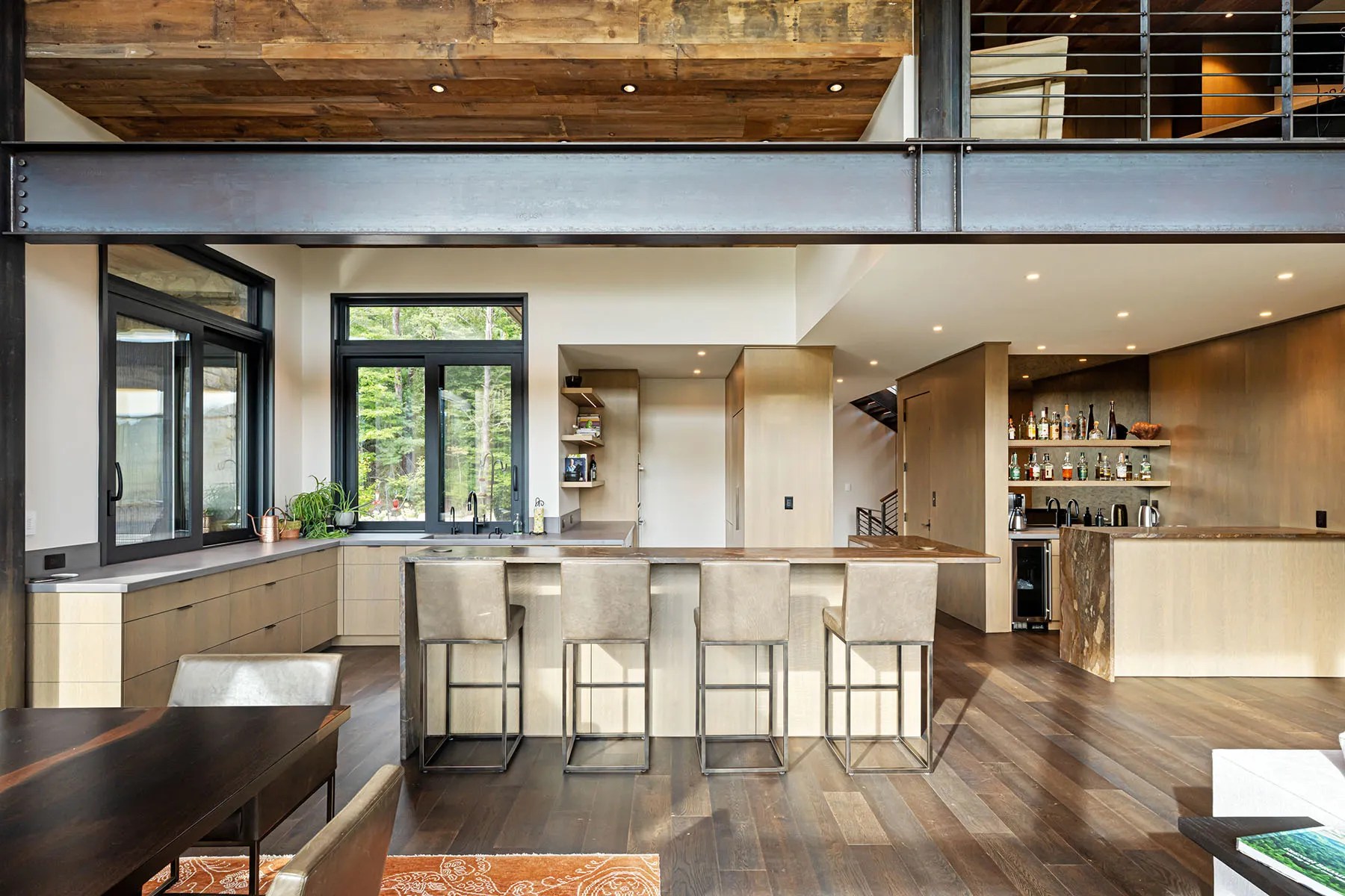 Open-concept living room with natural finishes and floor-to-ceiling windows overlooking nature

